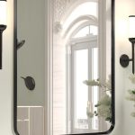 Brushed black metal wall-mounted vanity mirror with rounded corners in a modern bathroom