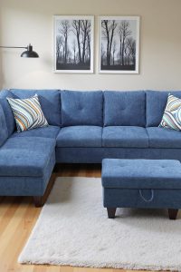 Front view of blue L-shaped sectional couch with chaise and storage ottomanUpholstered linen 3-piece modular sofa in small living room setup
