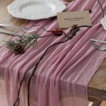 Dusty rose cheesecloth gauze table runner styled on a rustic wooden wedding table
