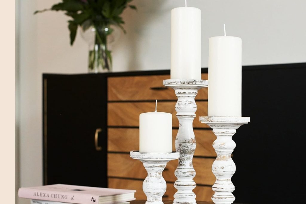 White rustic farmhouse-style large candle holders in a 3-piece set for pillar candles on table centerpieces.