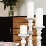 White rustic farmhouse-style large candle holders in a 3-piece set for pillar candles on table centerpieces.