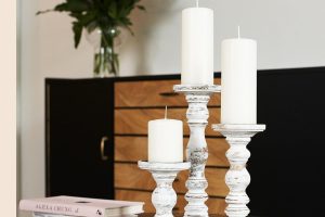 White rustic farmhouse-style large candle holders in a 3-piece set for pillar candles on table centerpieces.