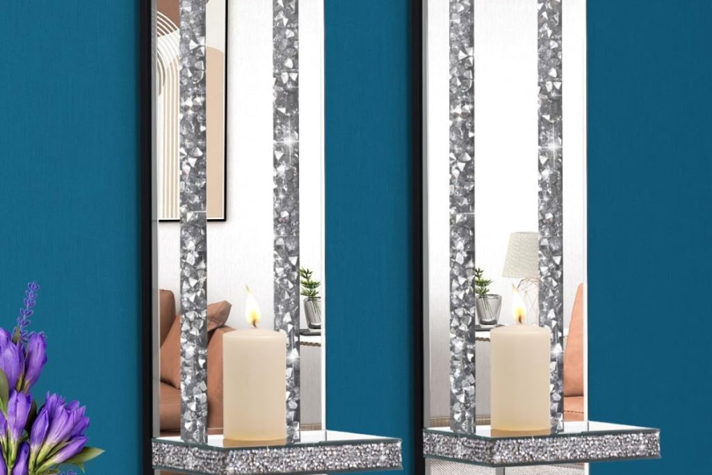 Elegant silver mirrored candle sconces with crushed diamond accents mounted on a living room wall.