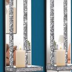 Elegant silver mirrored candle sconces with crushed diamond accents mounted on a living room wall.