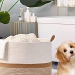 KAKAMAY Large Blanket Basket in white and brown cotton rope, perfect for baby laundry, pillows, or toys, placed in a cozy living room corner.