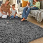 Soft grey fluffy Ophanie shag area rug in a cozy bedroom setting