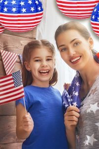 "Set of 10 red, white, and blue American flag paper lanterns hanging outdoors for 4th of July party decoration"