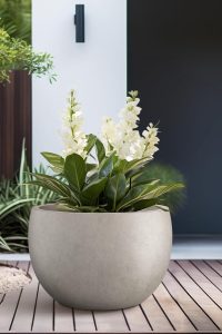 Kante 15.7-inch round concrete planter with weathered finish, shown empty on a patio.