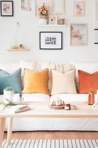 Colorful outdoor sofa decor with vibrant pillows, potted plants, and DIY lanterns in a cozy garden setting