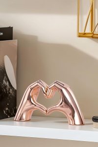 Pink heart hands statue used as a centerpiece on a modern coffee table