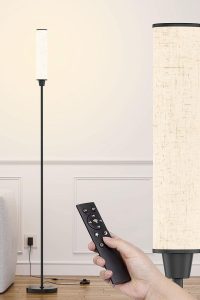 "Black floor lamp with beige linen shade and remote control in a cozy living room"