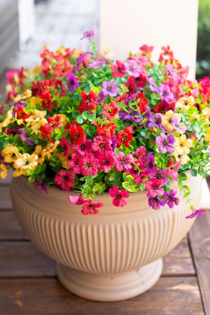 "Artificial daisy flower bundle with eucalyptus leaves in pink, red, purple, and yellow for home and garden decoration"