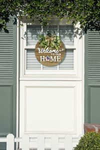 Rustic round wooden interchangeable welcome sign for front door, with seasonal icons for spring, summer, fall, and winter