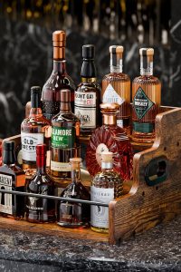 "KLM 3-tier liquor bottle display shelf on a kitchen countertop with whiskey and wine bottles"