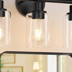 Black modern 3-light bathroom vanity light with clear glass shades mounted above a bathroom mirror