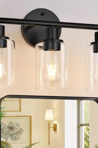 Black modern 3-light bathroom vanity light with clear glass shades mounted above a bathroom mirror