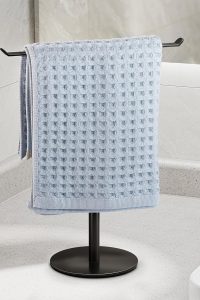 "T-Shape stainless steel towel rack on bathroom counter holding hand towels"