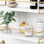 “Forbena white and gold floating bathroom shelves mounted above sink”