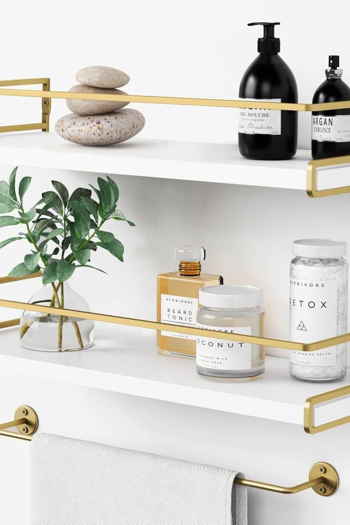 “Forbena white and gold floating bathroom shelves mounted above sink”