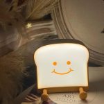 QANYI toast bread night light with smiling face on a teen girl’s nightstand