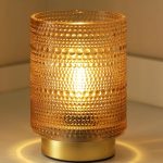 Golden cordless LED decorative lamp on a wooden bedside table, warm light glow