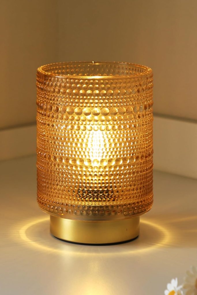 Golden cordless LED decorative lamp on a wooden bedside table, warm light glow