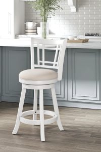 “Hillsdale Fairfox White Swivel Stool with Lattice Back next to a kitchen island”