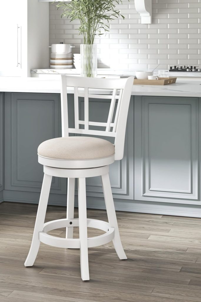 “Hillsdale Fairfox White Swivel Stool with Lattice Back next to a kitchen island”