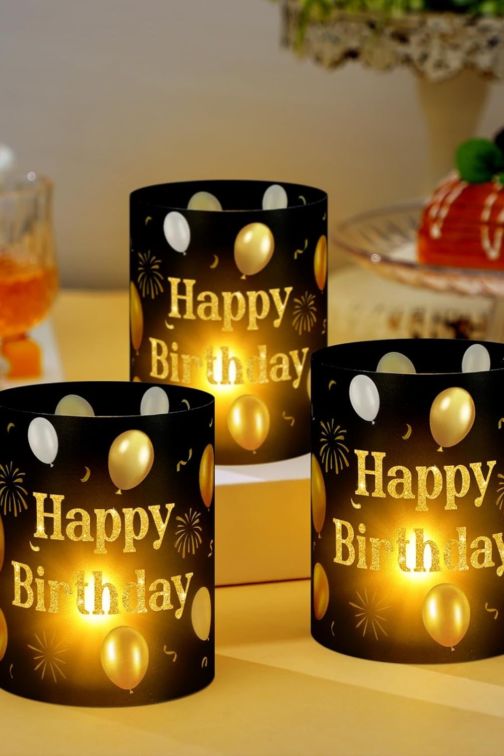 Black and gold Happy Birthday centerpiece lantern box with tea light candle on table.