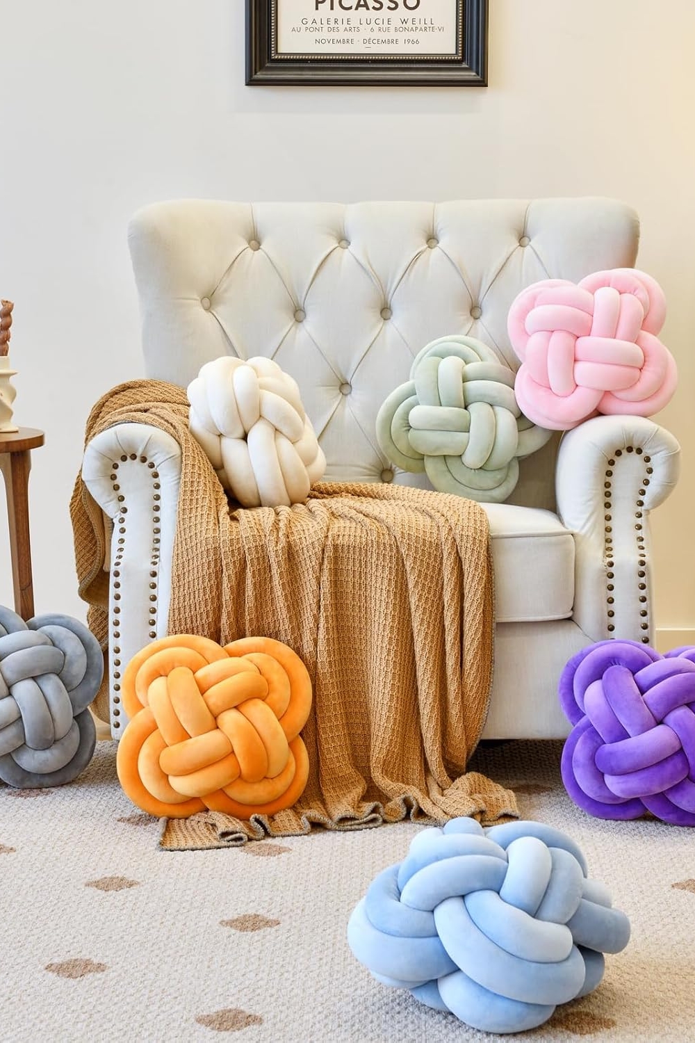 Xuyier 12-inch beige knot pillow ball on a modern living room couch