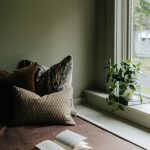 “cozy window reading nook with natural light and soft cushions”
