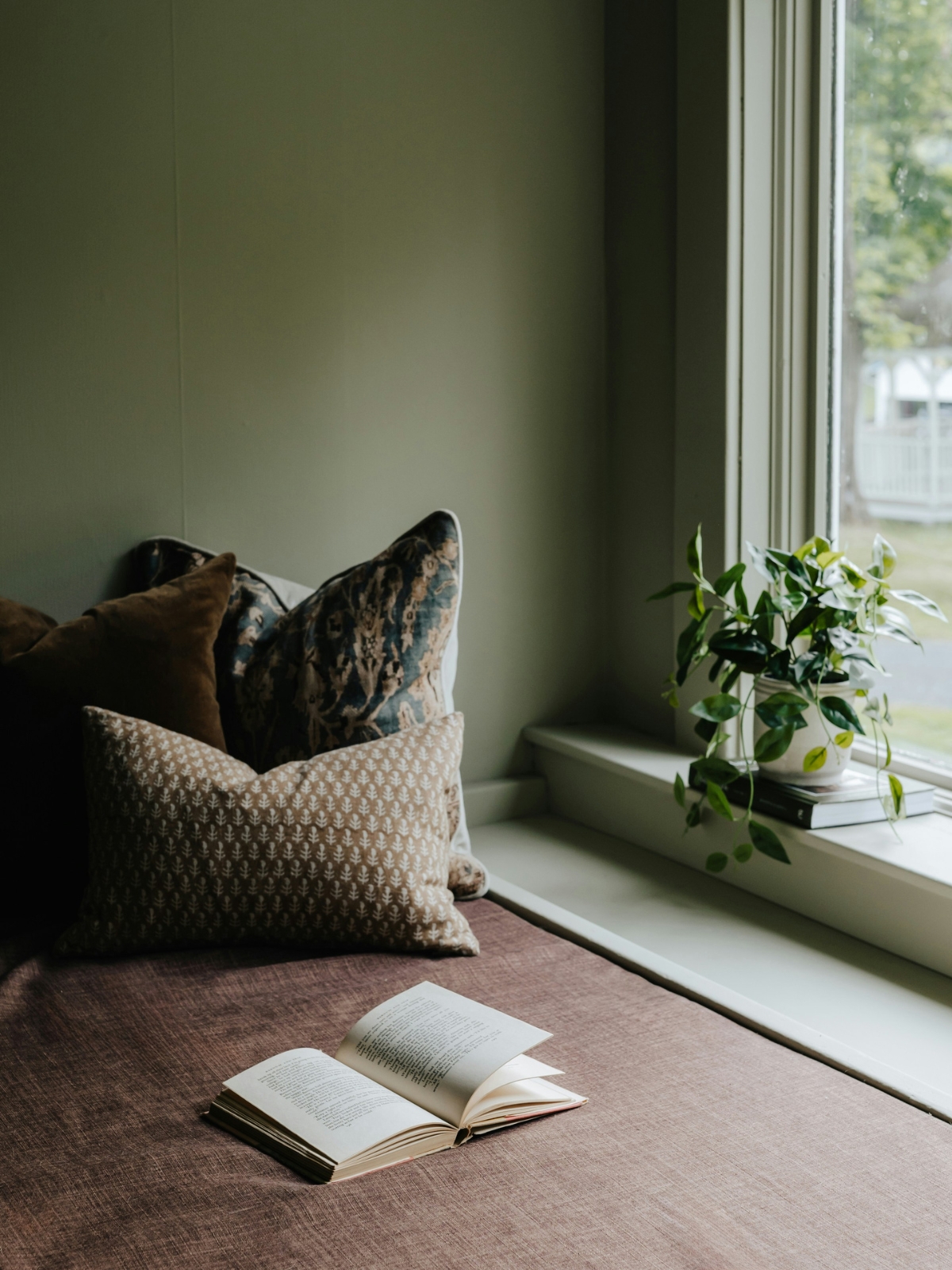 “cozy window reading nook with natural light and soft cushions”