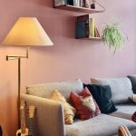 “Cozy reading nook in empty living room corner with armchair and floor lamp”