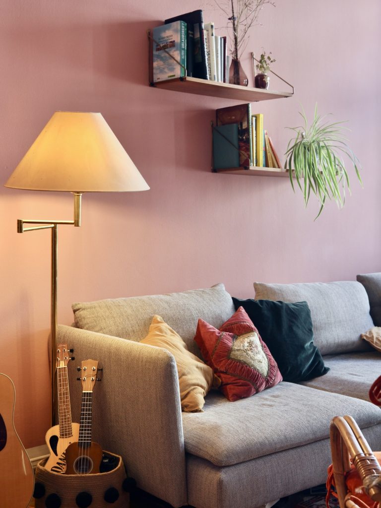 “Cozy reading nook in empty living room corner with armchair and floor lamp”