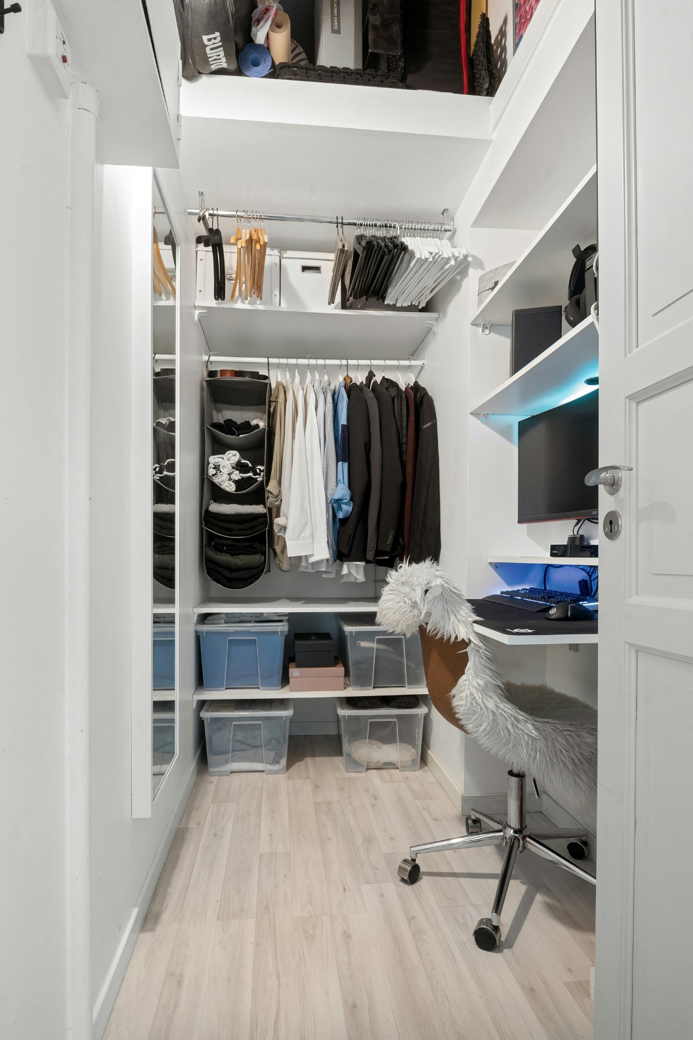 Small bedroom closet layout with hanging organizers and storage bins.