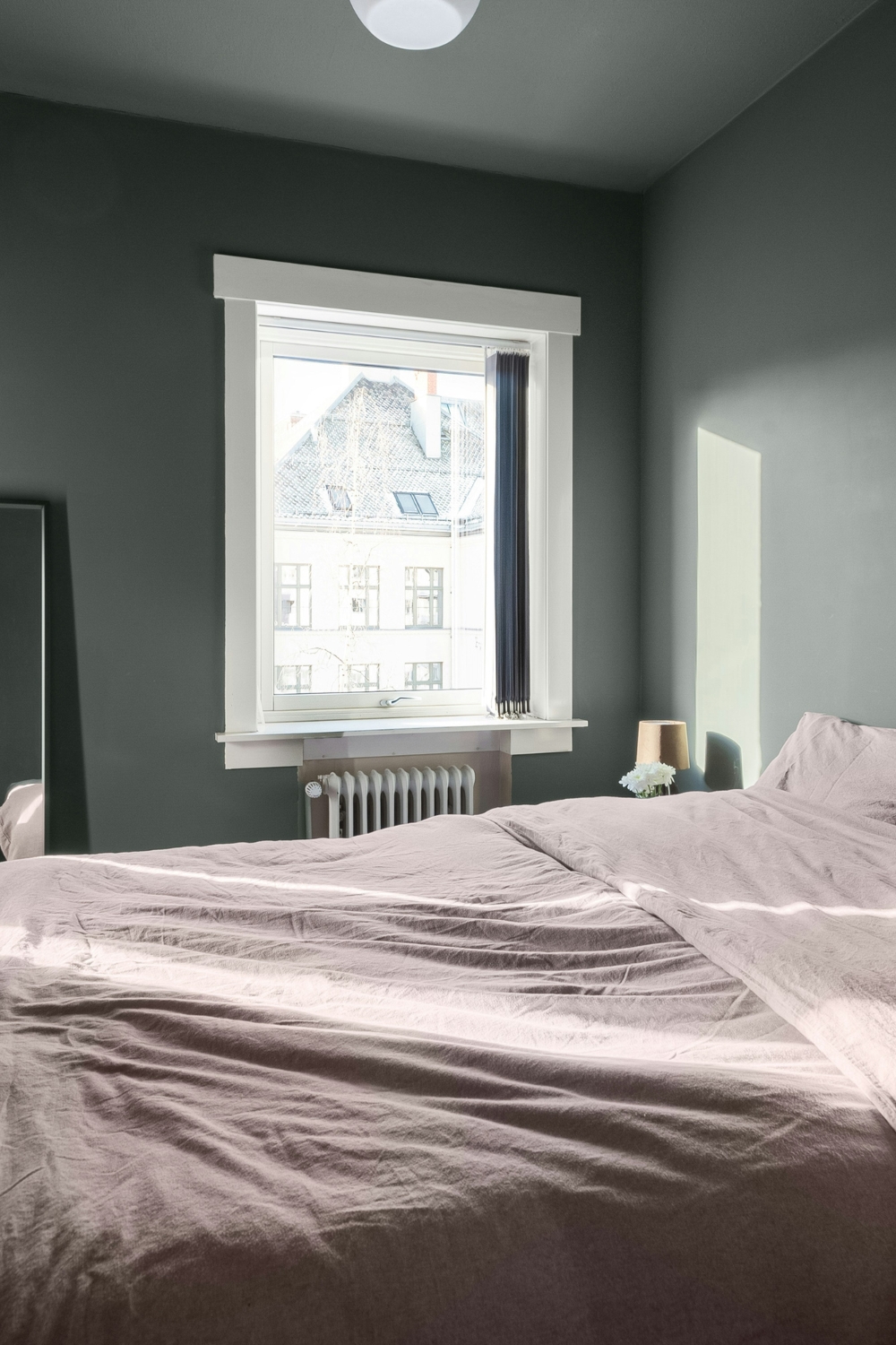 Small bedroom illuminated with layered LED and ambient lighting solutions.