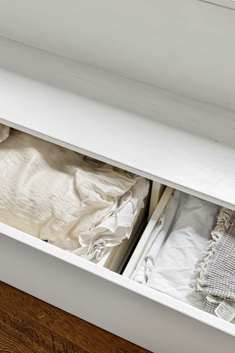 Under-bed storage drawers and boxes organized neatly in a small bedroom.