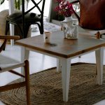 "Styled coffee table with books, flowers, and decorative tray in modern living room"