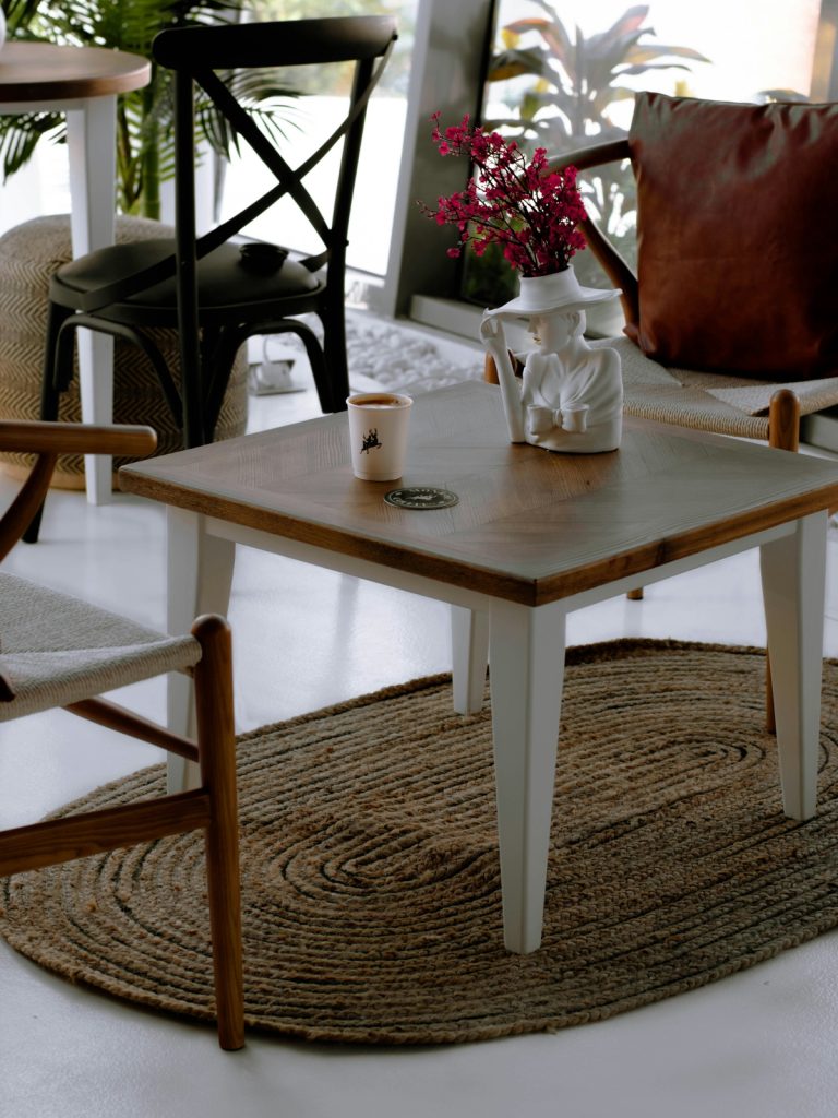 "Styled coffee table with books, flowers, and decorative tray in modern living room"