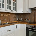 Rustic farmhouse kitchen with reclaimed wood shelves and vintage lighting
