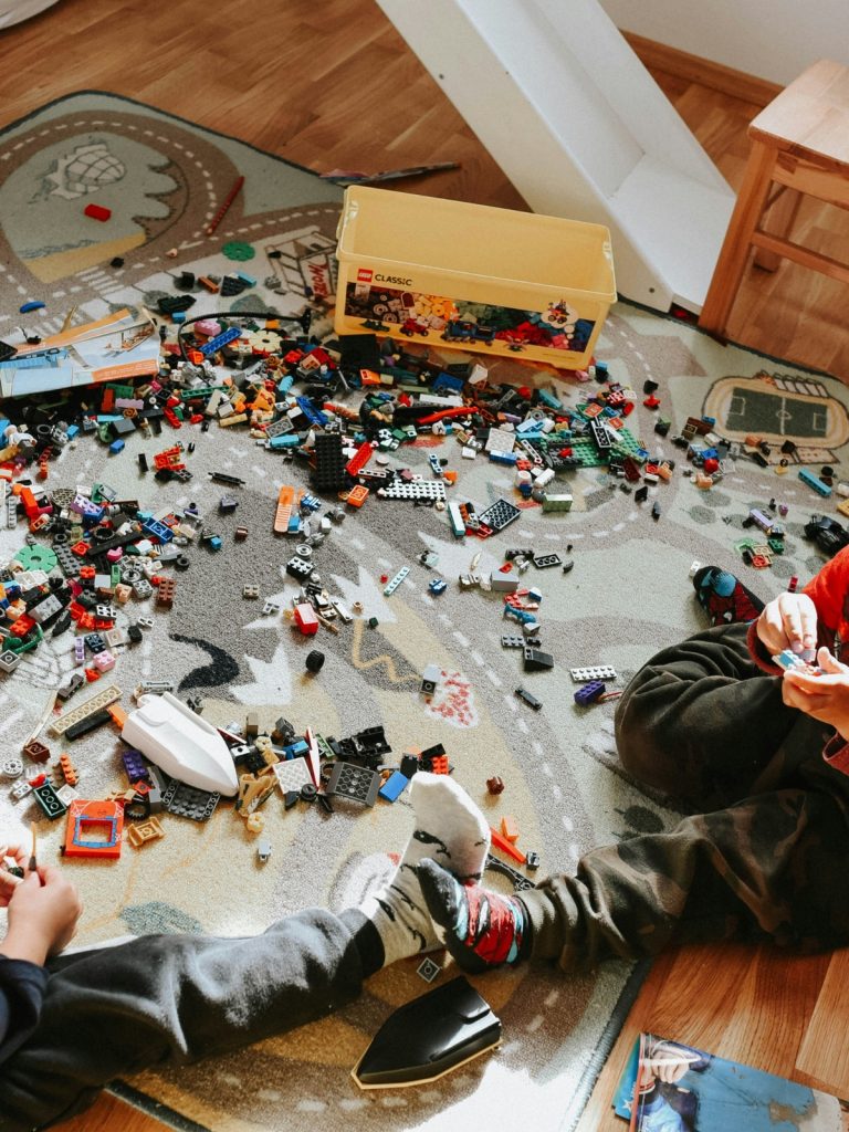 Clutter-free kids’ play corner with organized storage bins, low shelves, cozy rug, and smart lighting, creating a fun and functional play space