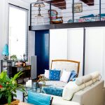 Cozy loft space with layered rugs, cushions, and functional furniture