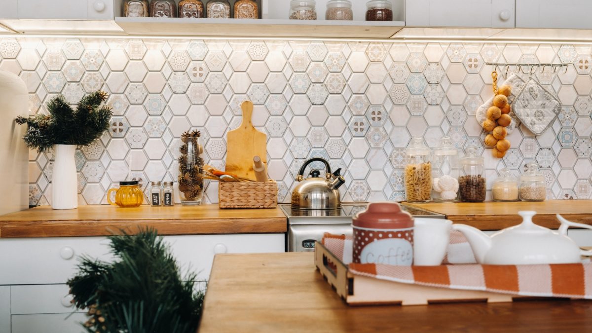 Modern kitchen with geometric tile backsplash in bold colors, highlighting 2026 wall decor trends.