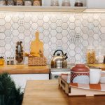 Modern kitchen with geometric tile backsplash in bold colors, highlighting 2026 wall decor trends.