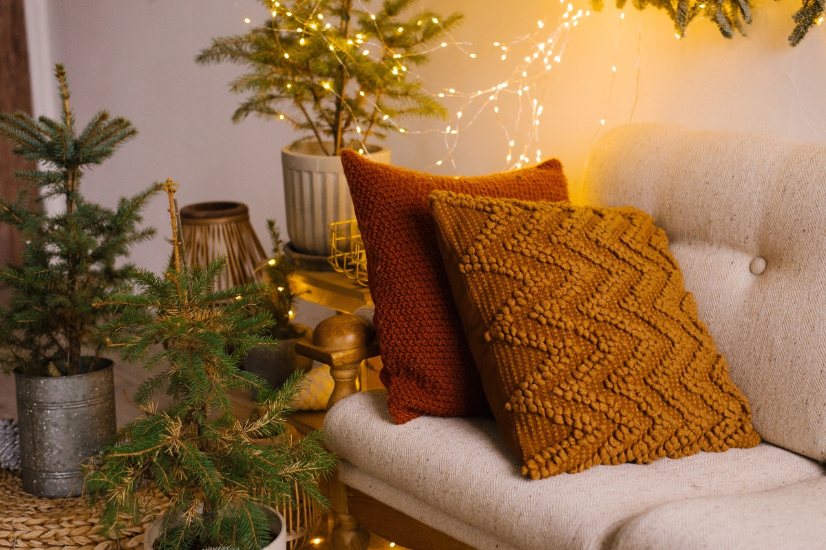 Cozy living room with warm ambient lighting from floor lamps, table lamps, and candles for a winter-ready home.