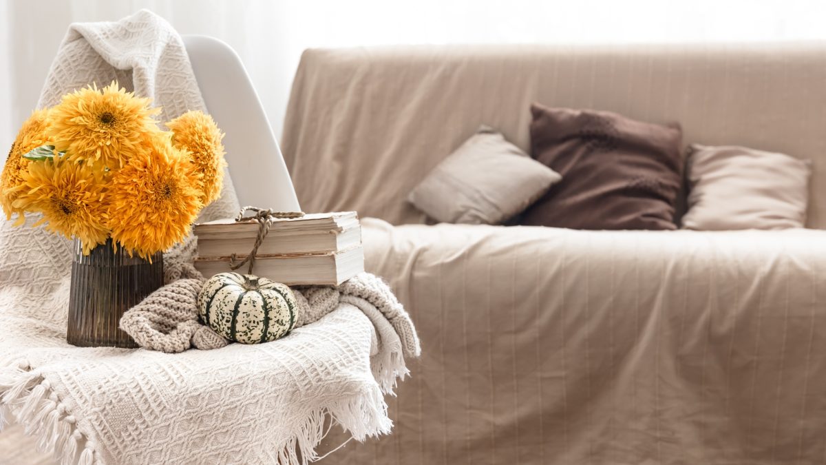 Living room styled with warm fall color palettes including terracotta and mustard