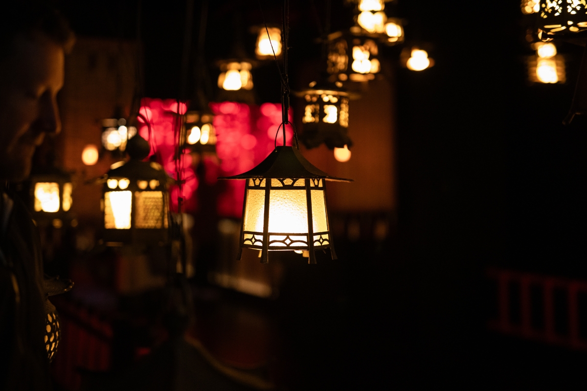 Modern living room showing layered lighting with statement chandelier, floor lamp, and accent lights for a cozy, stylish interior