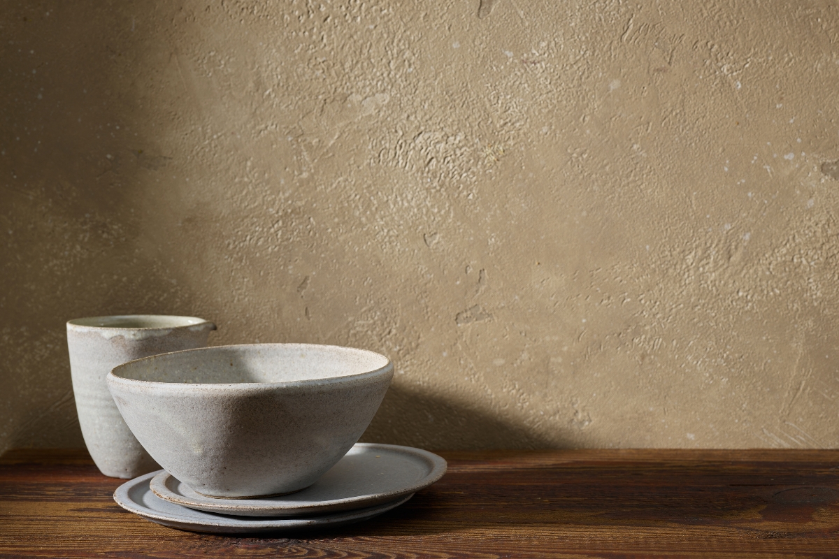 Neutral limewash wall finish behind modern upholstered bed in 2026 bedroom