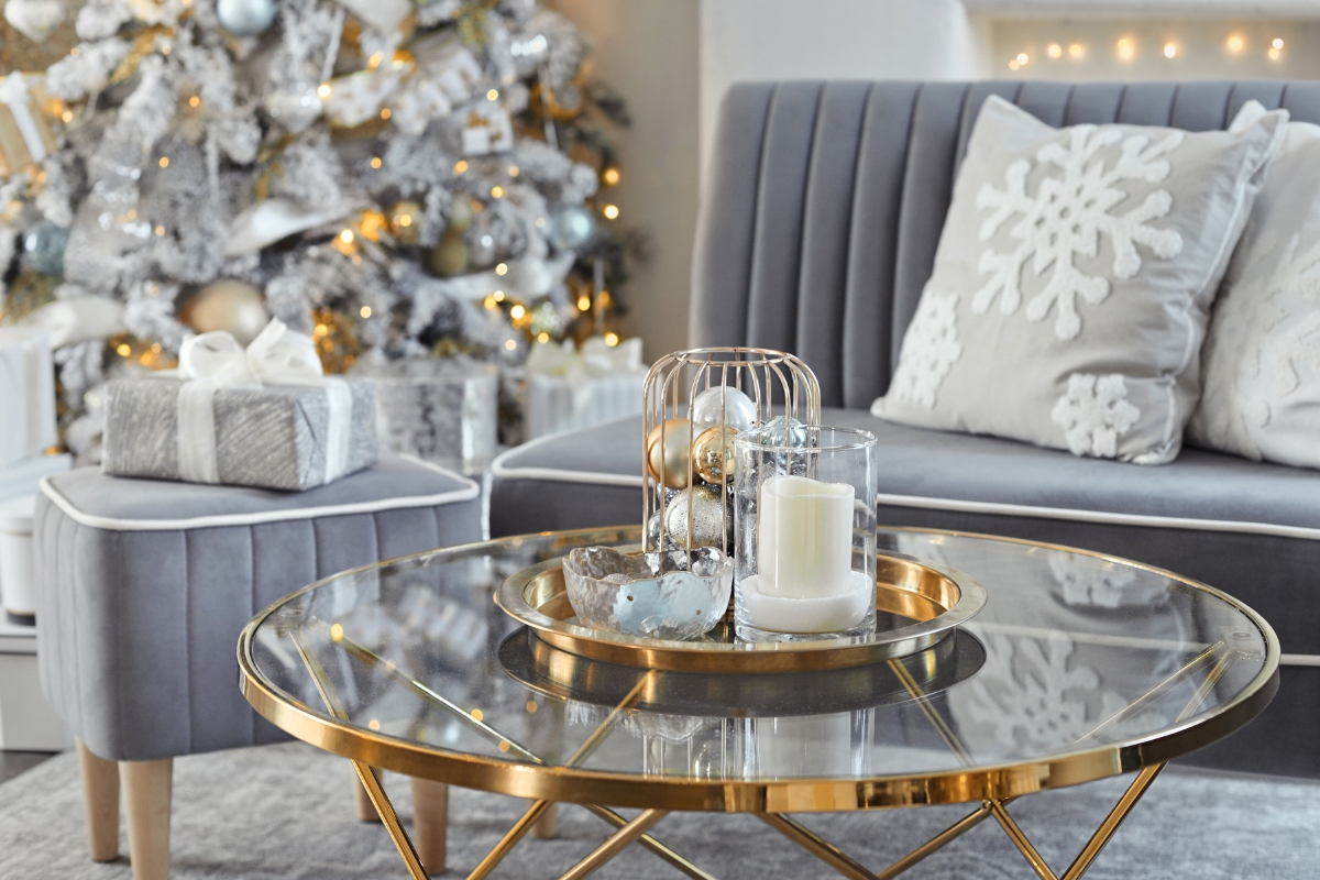 Winter living room with metallic and glass accents, including brass candle holders, trays, and reflective decor for a luxe holiday-to-winter look.