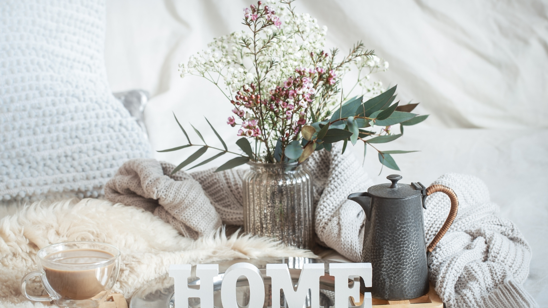 Bedroom styled with warm blankets, velvet pillows, and layered textures for winter